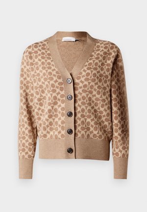 Gilet beige avec un motif circulaire marron, décolleté en V et six boutons foncés. Présente des poignets et un ourlet côtelés. Tissu doux et texturé.