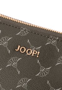 Tmavě zelená texturovaná peněženka s opakujícím se vzorem a zlatým logem "JOOP!" nad zlatým zipem.