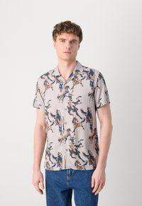 Short-sleeve, collared shirt in light beige with multicolored horse pattern, featuring buttons and a relaxed fit. Smooth texture.
