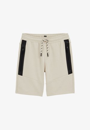 Bež bermude do koljena s elastičnim pojasom, crnim vertikalnim džepovima na patentni zatvarač sa obje strane i crno-bijelim vezicama.