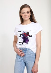 Biała koszulka bawełniana z grafiką przedstawiającą Ant-Mana w kolorze czerwonym i czarnym, z fioletowymi plamami w tle oraz tekstem "ANT-MAN" w pionie.