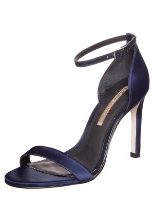 Einzelne marineblaue Satin High-Heel Sandale mit Knöchelriemen und offenem Zehenbereich auf weißem Hintergrund.