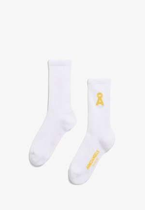 Weiße Baumwoll-Crew-Socken mit gerippter Textur, die auf einer Socke ein gelbes gesticktes Logo und Text aufweisen. Standarddesign, knöchelhöhe.