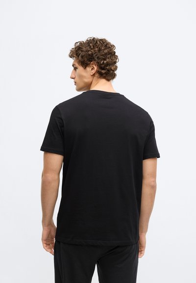 Čierne tričko s krátkym rukávom a okrúhlym výstrihom, vyrobené z hladkej látky. Má voľný strih a minimalistický dizajn bez viditeľných vzorov alebo doplnkov.