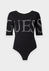 Body nero con scollatura rotonda e maniche a tre quarti. Presenta un grande testo "GUESS" in strass su entrambe le maniche. Tessuto liscio.