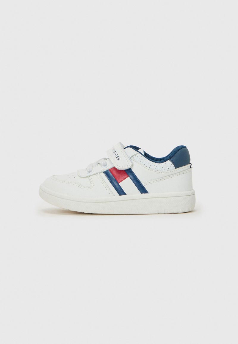 Sneaker blanc avec des rayures bleues et rouges, en matériau synthétique, texture lisse, design bas, sangle Velcro et semelle en caoutchouc.