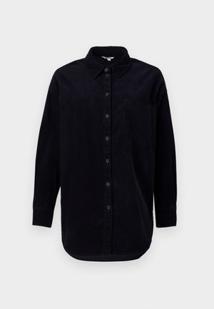 Chemise en velours côtelé noir à manches longues, avec un devant boutonné et une poche poitrine. Présente un ourlet arrondi et un tissu texturé.