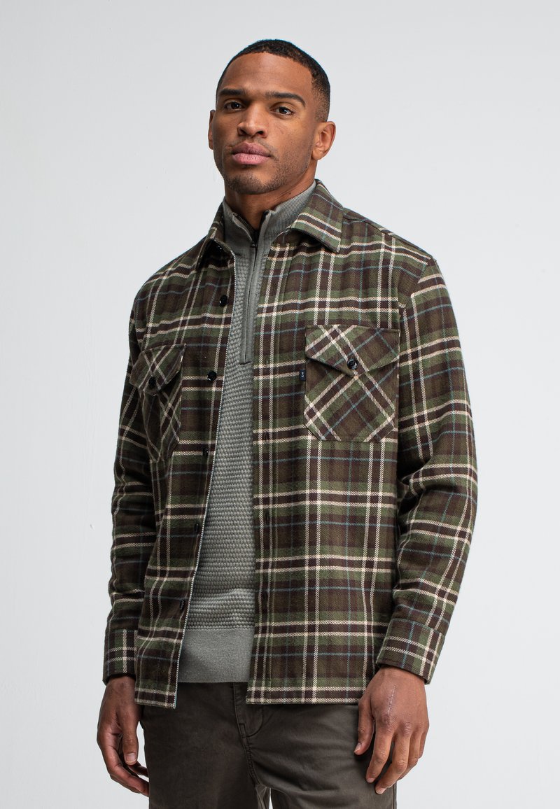 Flanellen overhemd in donkergroen ruitpatroon met witte en bruine accenten, voorzien van twee borstzakken en een knoopsluiting. D gedragen over een gestructureerde grijze trui.