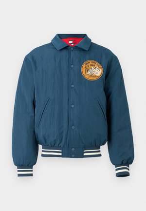 Marineblaue Bomberjacke mit Knopfverschluss, gerippten Bündchen und Saum. Verfügt über einen runden, gestickten Patch mit "New York City 1985" und einem Bergdesign.