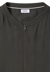 Ciemnozielona kurtka bomberka z okrągłym dekoltem, zamkiem błyskawicznym i kontrastującym paskiem przy szyi. Gładka faktura tkaniny, minimalistyczny design.