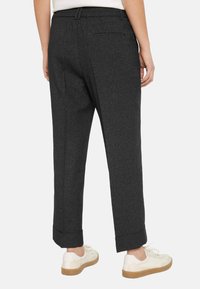 Gray wool trousers with a straight leg design, featuring a cuffed hem and two back pockets, paired with white sneakers.