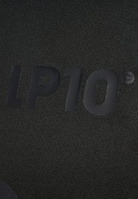 Sort stof med en mat tekstur, der har det præget tekst "LP10" og en cirkulær accent. Designet er enkelt og moderne.