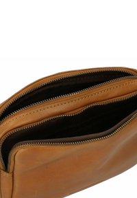 Borsa in pelle marrone con una texture liscia, dotata di due scomparti separati da cerniere e dettagli di cucitura visibili lungo i bordi.