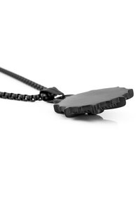 Collier pendentif noir avec un bord dentelé, fabriqué à partir d'un matériau lisse, monté sur une chaîne à maillons qui dispose également d'un fermoir.