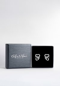 Boucles d'oreilles en argent en forme de cœur avec une finition polie, ornées d'accents transparents et scintillants. Présentées dans une boîte doublée de velours noir.