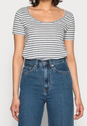 Chemise rayée à manches courtes, couleurs gris clair et bleu marine, encolure dégagée. Assortie à un jean en denim bleu taille haute.