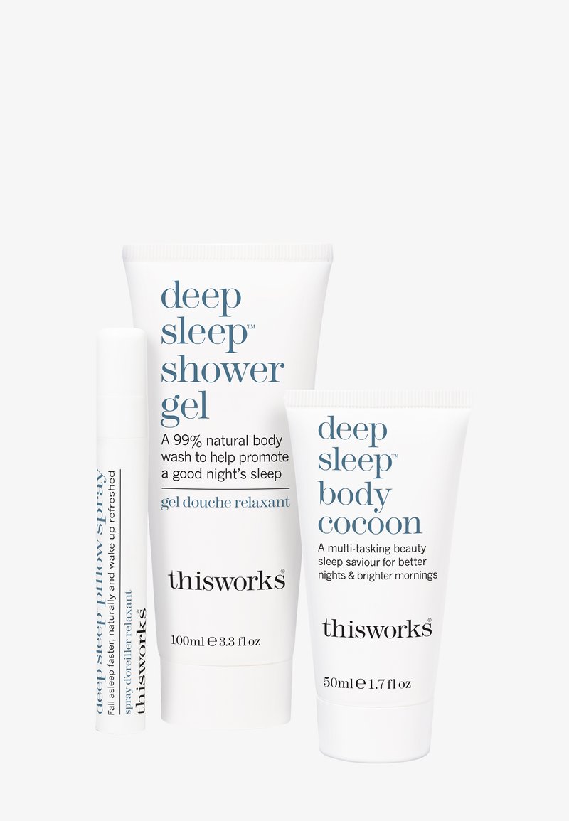 Kolme ihonhoitotuotetta valkoista taustaa vasten: sumutus, suihkugeeli putkilossa ja vartalokovetti, kaikki nimeltään "deep sleep" merkiltä This Works.