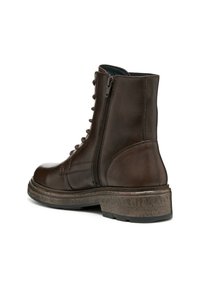 Bottine en cuir marron avec une semelle texturée, un laçage à l'avant et une fermeture éclair sur le côté. Elle possède un embout arrondi et un talon large et robuste.