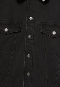 Camicia in denim nero con bottoni a pressione in metallo, due tasche sul petto e cuciture a contrasto. Tessuto strutturato con un aspetto leggermente sbiadito.