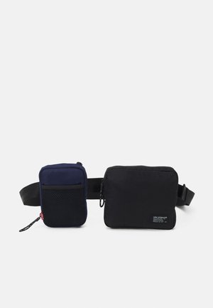 Bæltetaske med to rektangulære lommer, en navyblå med netlomme, en sort med lynlås og Levi Strauss-mærke, fastgjort til justerbar sort rem.