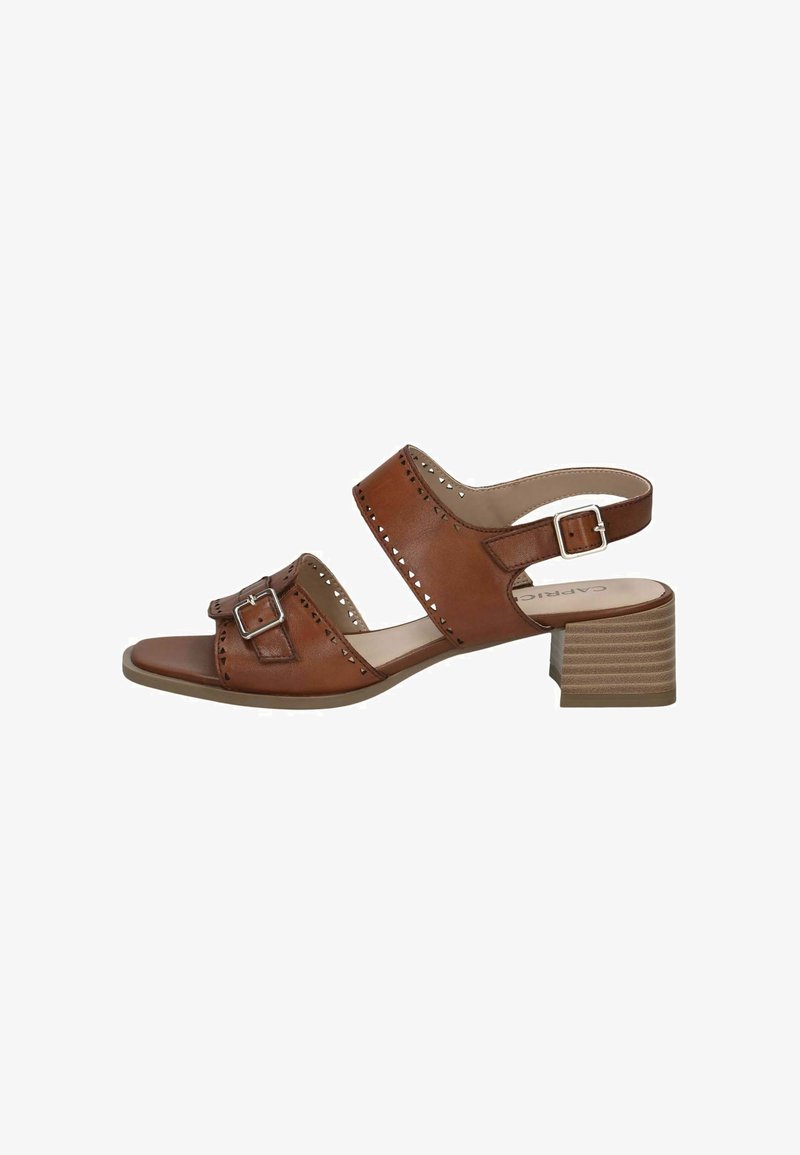 Sandale en cuir marron avec deux larges brides, détail de boucle et découpes perforées. Dotée d'un petit talon bloc avec une finition texturée.
