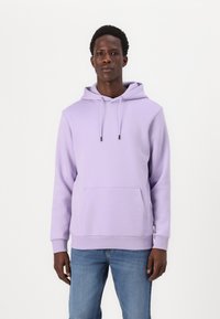 Light purple hoodie made of soft fabric, featuring a front kangaroo pocket and adjustable drawstring hood. Paired with blue jeans.