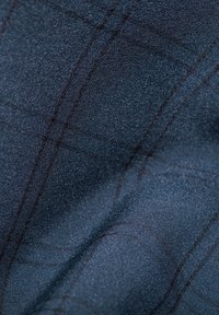 Granatowy materiał z subtelnym wzorem w kratkę, teksturowana powierzchnia i cienkie linie biegnące po skosie, tworzące uporządkowany wygląd.