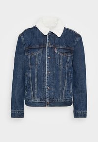 Giacca di jeans blu scuro con colletto in pile bianco, due tasche sul petto e chiusure a bottoni classiche. Presenta una texture sbiadita.