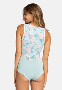 Lyseblå ett-dels badedrakt med et blomsterdesign i rosa og teal på baksiden, med høy hals og uten ermer.
