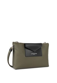 Borsa sintetica verde oliva con patta in pelle nera, chiusura con zip e tracolla removibile. Presenta un logo argentato sul fronte.