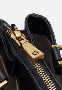 Czarna skórzana torebka z złotym metalowym zamkiem. Charakteryzuje się prostokątnym kształtem, gładką fakturą oraz zamkiem z logo.