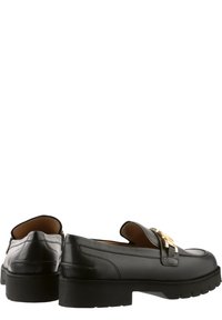 Sorte læder loafers med flad, struktureret sål, der har en guld hardwaredetalje på remmen og en glat finish.