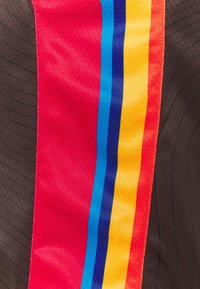 Tessuto sportivo con uno sfondo nero testurizzato e una striscia verticale multicolore (rossa, blu, gialla) con tocchi di texture liscia.