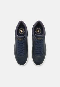 Sneakers din piele bleumarin cu design cu șireturi, guler căptușit, talpă din cauciuc alb contrastant și branțuri cu marcaj. Finisaj neted cu detalii de cusătură.
