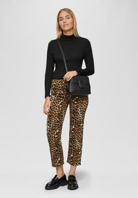 Zwarte coltrui, leopardprint hoge taillebroek, zwarte schoudertas, glanzende zwarte loafers, standaard pasvorm, gladde textuur.