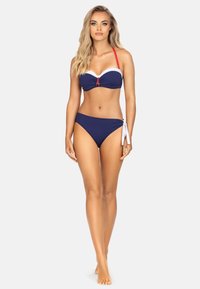 Bikini w kolorze granatowym, składający się z bandeau górnej części z białymi i czerwonymi akcentami, regulowanymi czerwonymi ramiączkami oraz dopasowanych, niskich majtek z bocznymi związaniami.