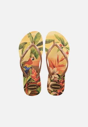 Flip-flops with tropical design featuring a parrot, green leaves, orange flowers, and bronze straps with "Havaianas" logo.