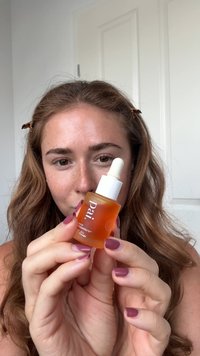 Pai Regenerate gezichtsolie in een heldere glazen fles met een witte druppelkap, met een oranje vloeistof en een minimalistisch tekstontwerp.