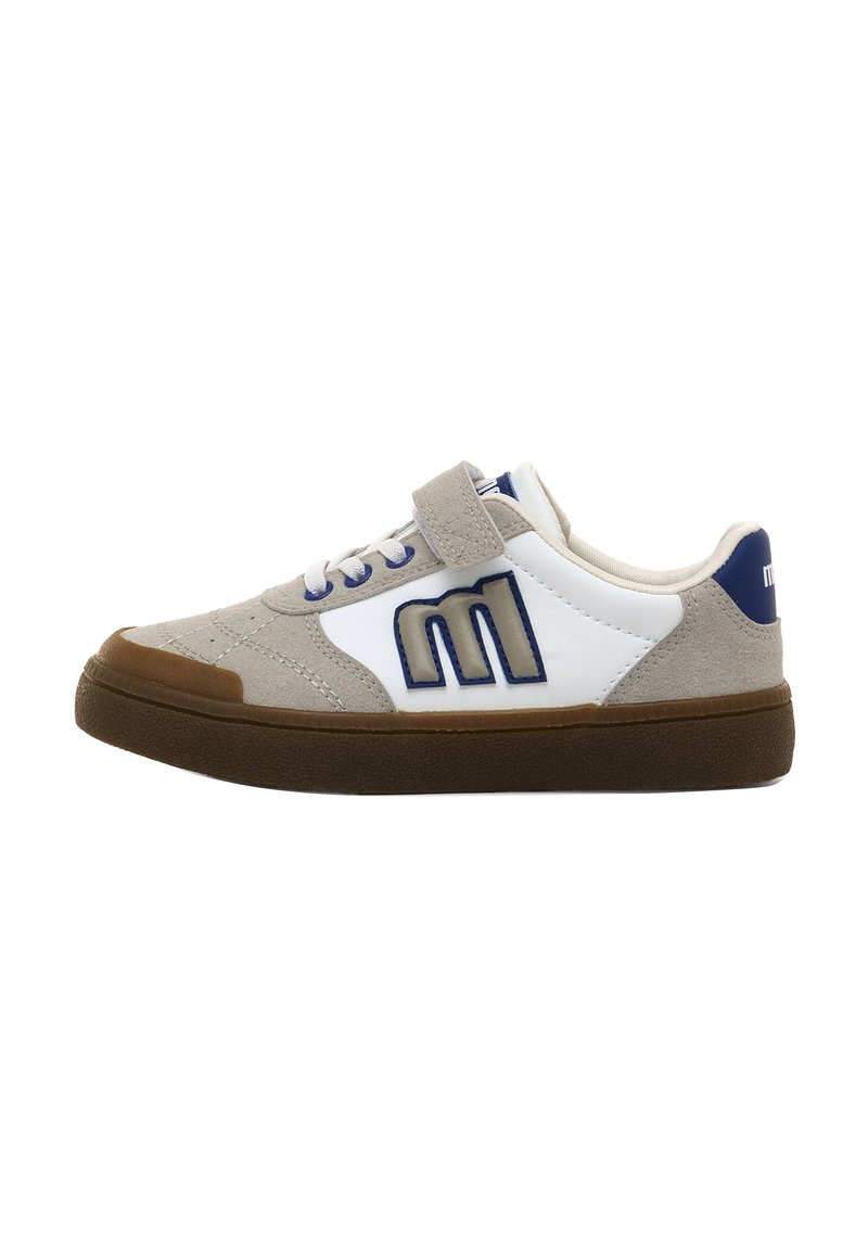 Zapatilla baja de ante beige, con paneles blancos, logo "M" azul, suela de goma marrón, cordones y una correa de velcro sobre un fondo blanco.