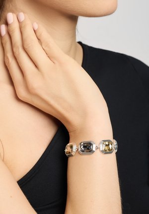 Silberarmband mit drei rechteckigen, facettierten Steinen in Grau, Gelb und Braun, mit einer strukturierten, polierten Oberfläche.