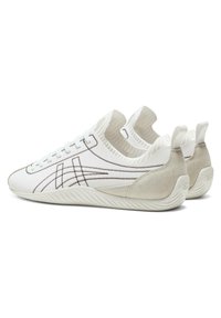 White sneakers with a textured upper, contrasting brown stitching, and suede accents. Features a low profile and flexible rubber sole.