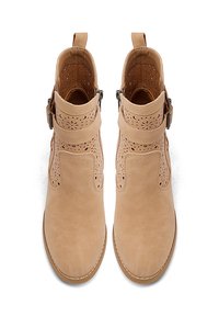 Stivaletti alla caviglia di colore tan realizzati in pelle testurizzata, con motivi ritagliati, un'accento di fibbia e una punta tonda con dettagli cuciti.