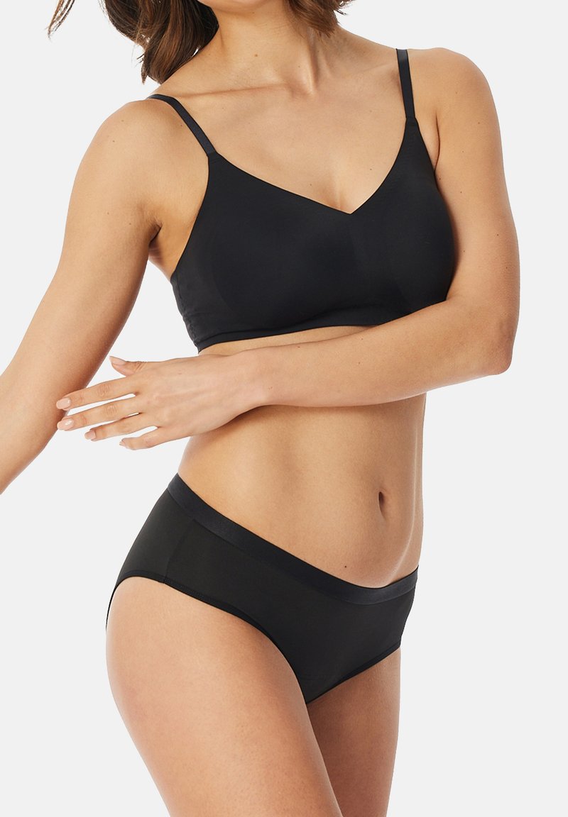 Schwarzes Bralette mit dünnen Trägern, das eine glatte Textur und einen U-förmigen Ausschnitt aufweist, kombiniert mit passenden hochgeschnittenen schwarzen Panties.