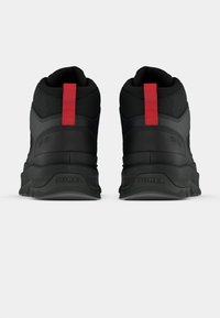 Pantofi negri tip gheată, cu material texturat, având un etichete roșii și branding Sorel pe călcâi. Talpă din cauciuc pentru aderență.