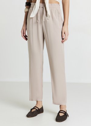 Pantalon beige clair, coupe décontractée, avec une taille élastique et un cordon de serrage. Le tissu est lisse et fluide, avec une coupe droite.