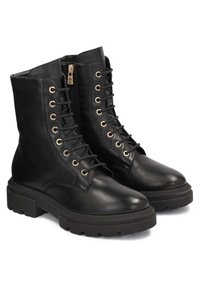 Botines de cuero negro hasta el tobillo con cordones en el frente, ojales dorados, cremallera lateral y suela de goma texturada. Diseño grueso y acabado suave.