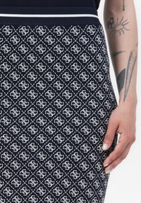 Gonna in maglia blu navy con motivo geometrico bianco, vita a coste con strisce bianche e silhouette aderente.