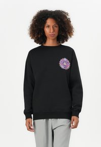 Black sweatshirt with long sleeves, ribbed cuffs, and a round neckline. Features a colorful floral design on the left chest area.