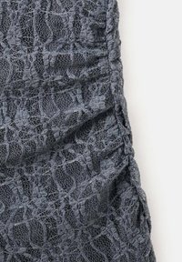 Tăietură din dantelă gri cu un model floral detaliat, având un design plisat și o textură delicată. Aspect moale, semi-transparent.