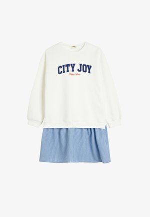 Hvid sweatshirt med teksten "CITY JOY" i marineblå, der har en blå og hvidstribet nederdel fastgjort i taljen. Blødt bomuldsmateriale, afslappet pasform.